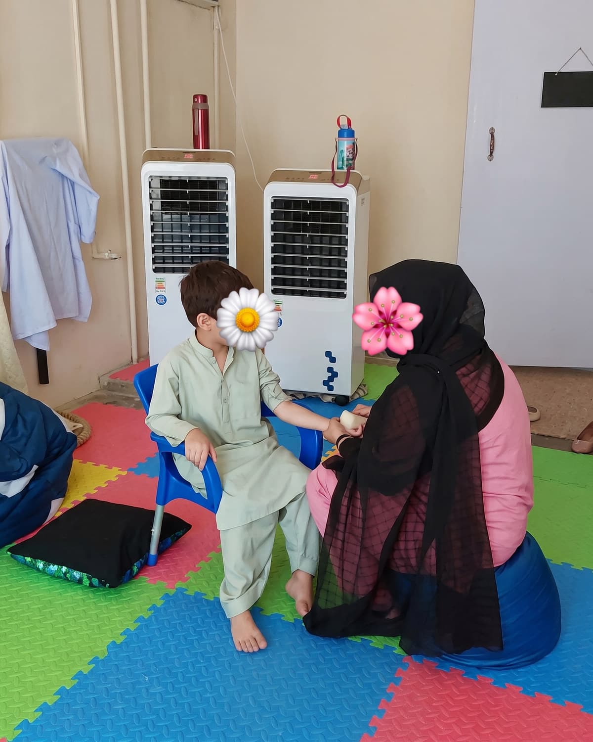 A child and teacher playing together on the colourful sensory mat