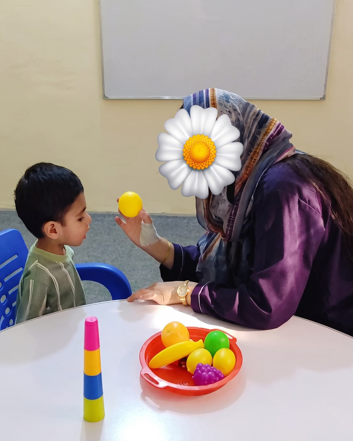 A child holding a yellow ball during a colour-sorting game