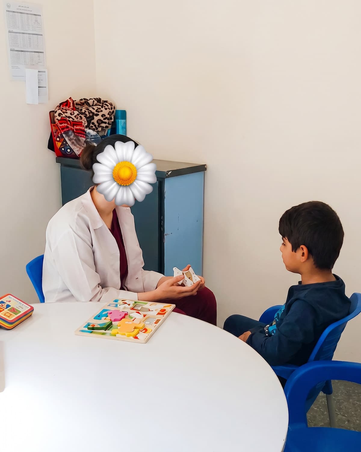 A teacher and child working through table-top learning materials