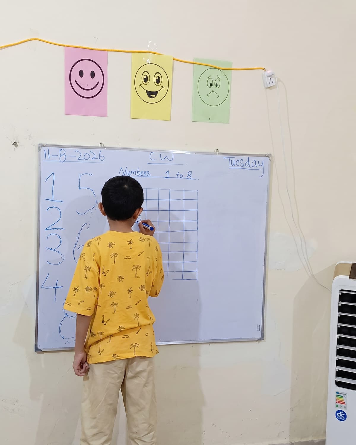 A boy working through an exercise at the classroom whiteboard