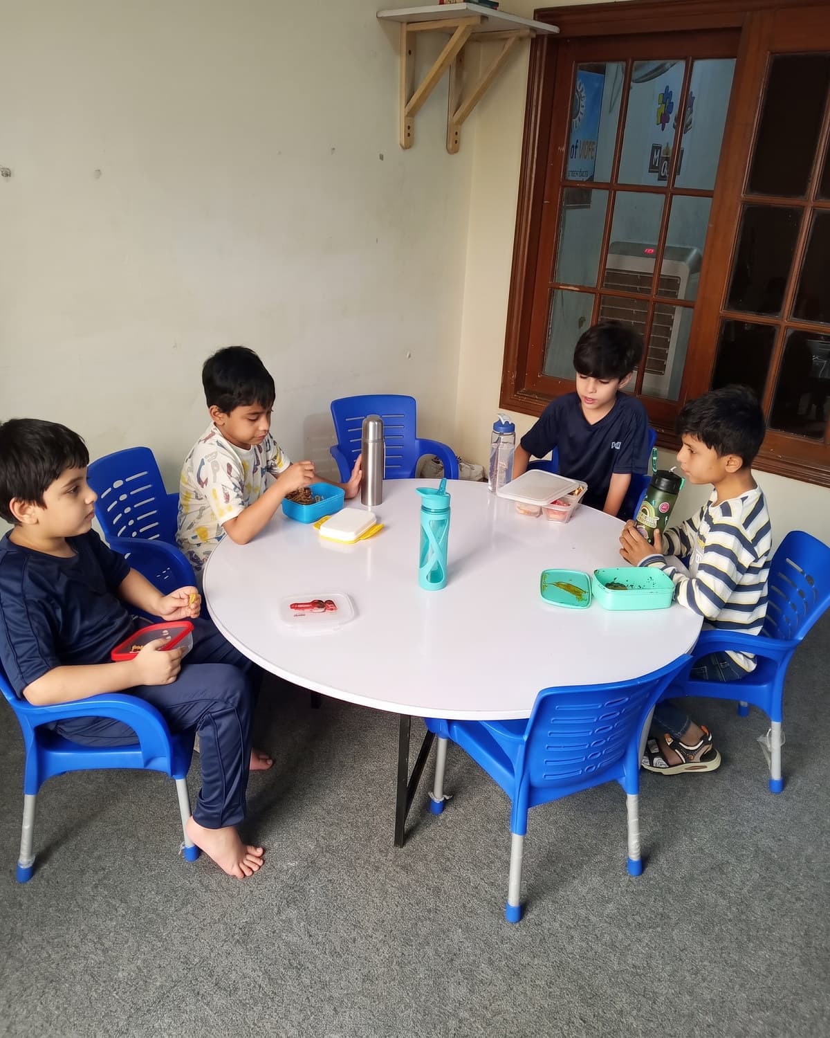 Children at the round table with coloured blocks and cups