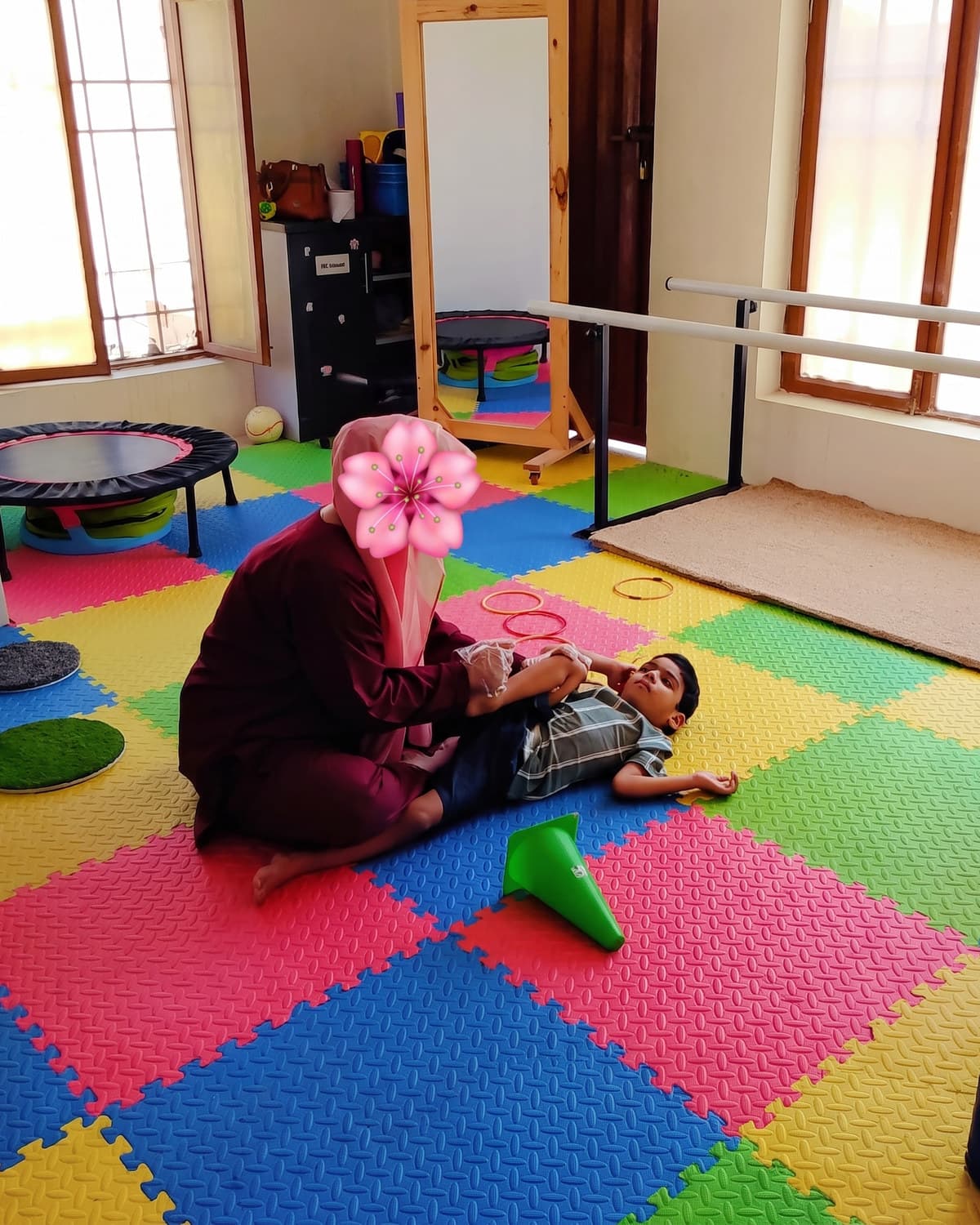 A therapist and child working together on the soft play mat